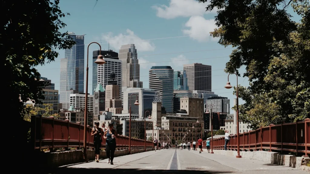 People jogging in the street. Image of Minneapolis stone arch bridge for article on Minnesota corporate state taxes.