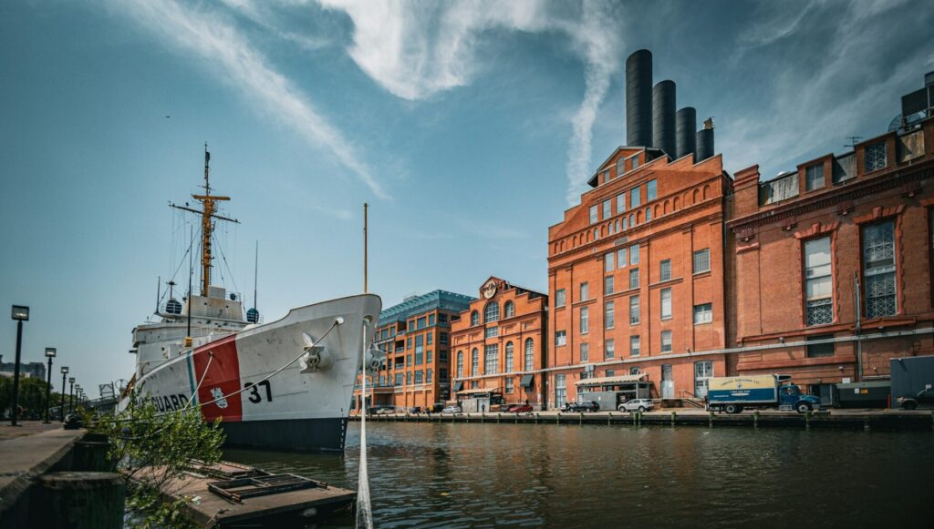A large boat sitting in the water next to a building.