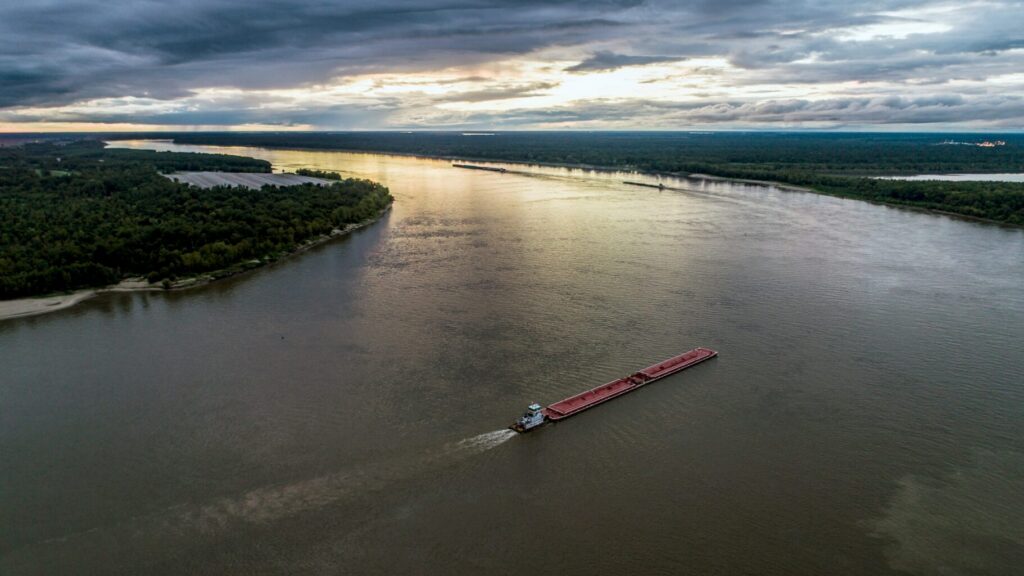 Aerial view of a red boat on the Mississippi River.