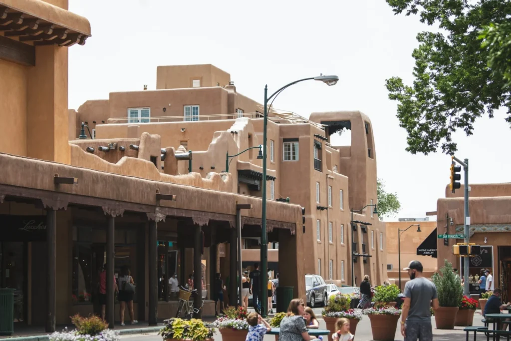 A vibrant street view of historic adobe-style buildings and shops in Santa Fe, New Mexico. This iconic Southwestern architecture reflects the unique business landscape of the state, where staying competitive is a key focus of the New Mexico corporate tax rate.