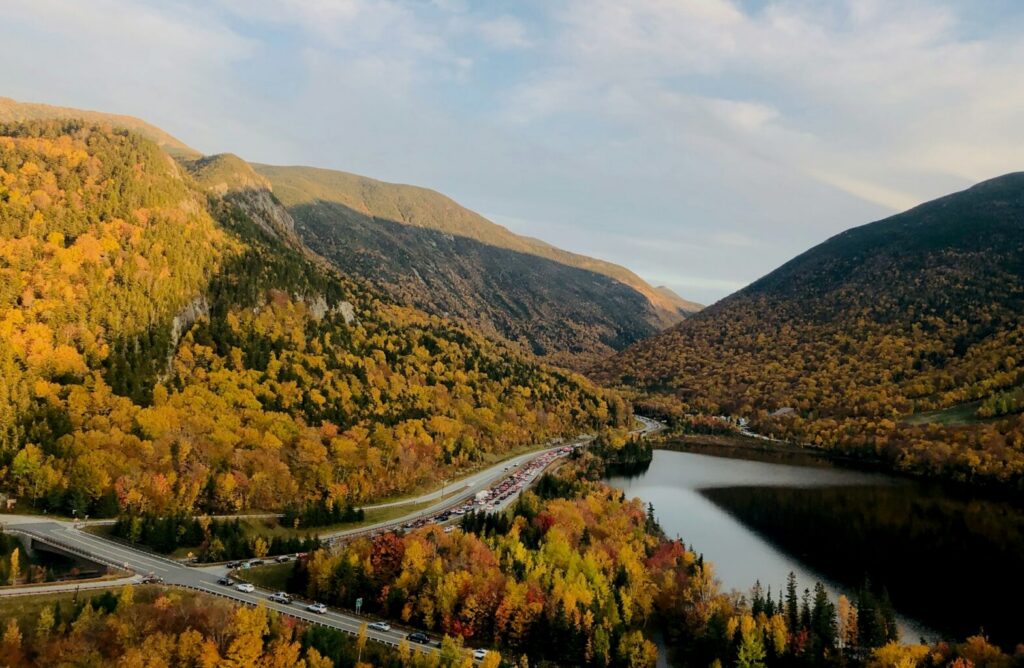 Green and brown mountains beside river during daytime