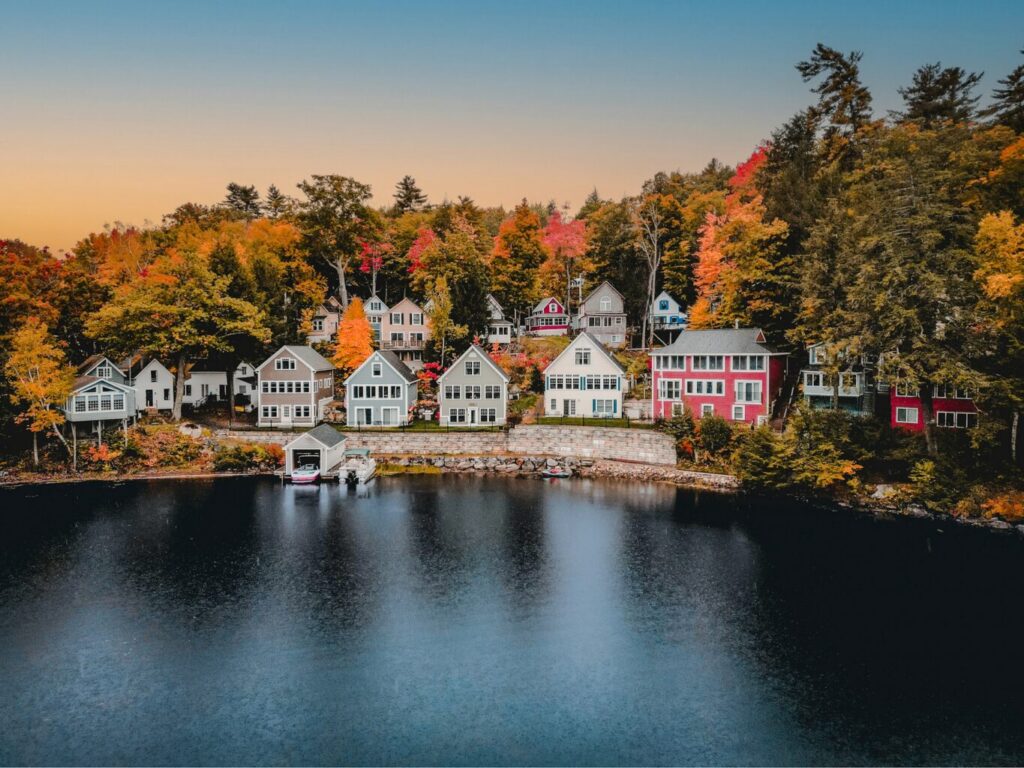 An aerial view of homes on Lake Winnepesauke, New Hampshire during peak foliage season.