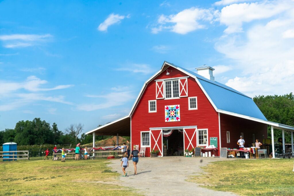 A red barn with people standing in front of it