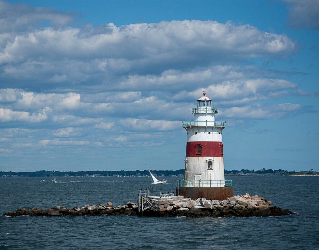 Red and white lighthouse on top of a pier.