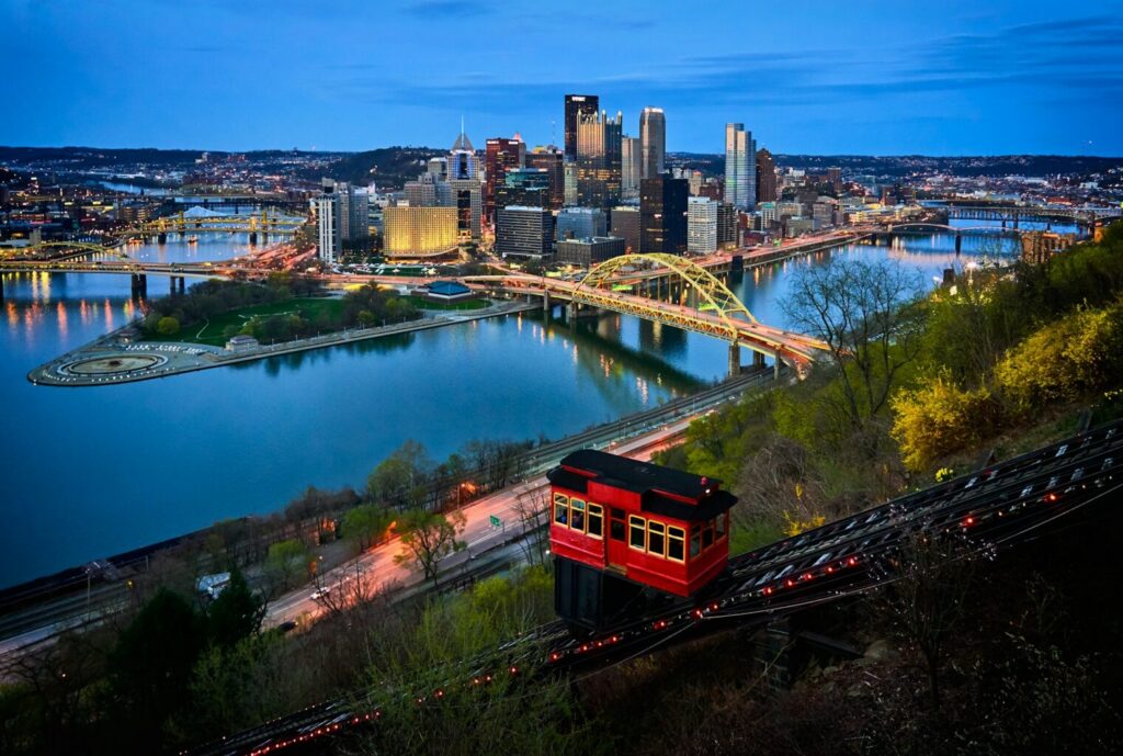 Aerial photo of bridge and buildings under blue sky.