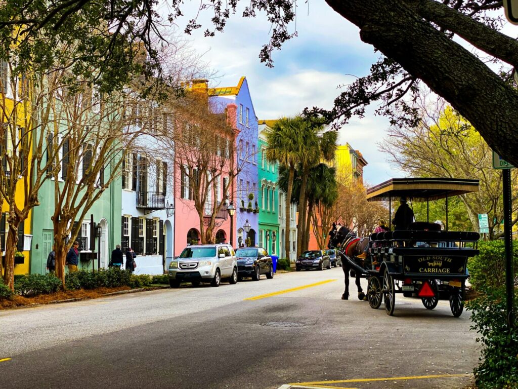 Image of colourful buildings and people riding on a carriage on the road during daytime.
